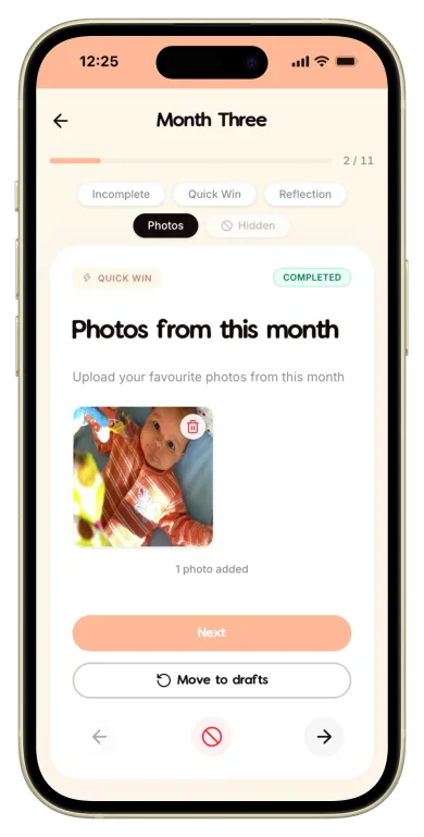 The Makia app on a phone, open to the Month Three prompt "Photos from this month", with the smiling play-gym photo added