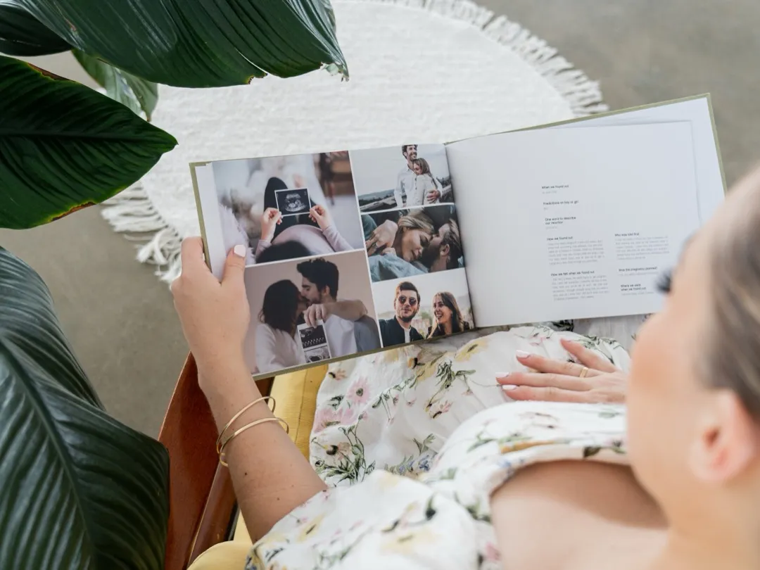 A pregnant mother reads through her Baby Bump journal, including her ultrasound photo.